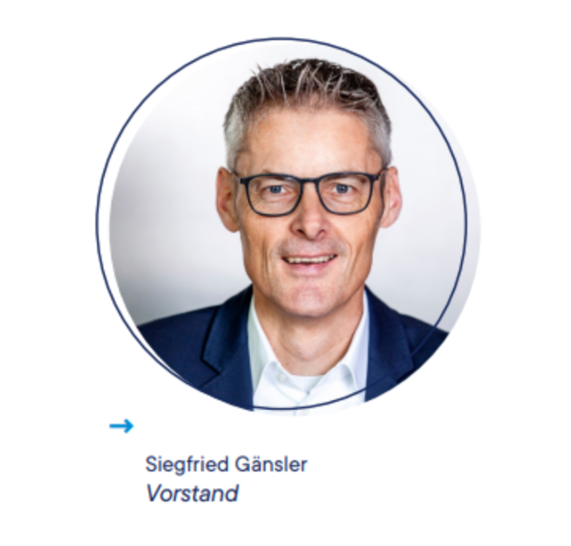 Porträt eines Mannes mit kurzen grauen Haaren und Brille, der eine dunkle Jacke und ein weißes Hemd trägt. Unter dem Foto steht der Name "Siegfried Gänsler" und das Wort "Vorstand" mit einem blauen Pfeil, der nach rechts zeigt.